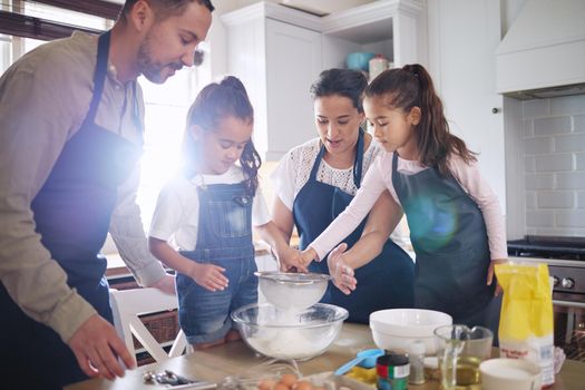 We bake for every occasion. Shot of a couple and their children baking together at home.