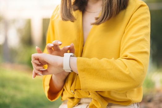 Close up of woman hand with smartwatch. Checking incoming notification on smart watch. Scrolling display on smartwatch. Caucasian girl using smartwatch