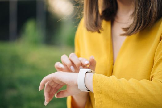 Checking incoming notification on smart watch. Scrolling display on smartwatch. Caucasian girl using smartwatch. Close up of woman hand with smartwatch