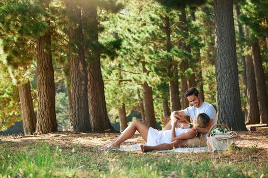 A picnic in the forest restores everything. Shot of a young couple having a picnic in the forest.