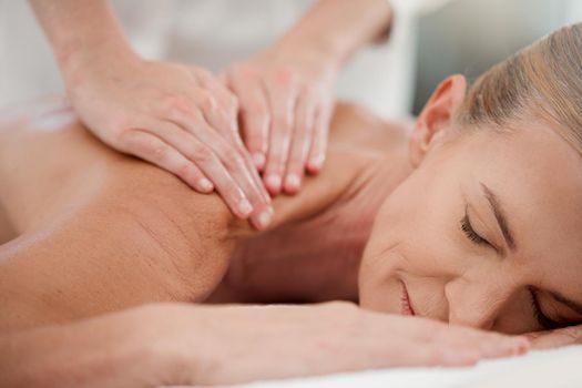 Light pressure is all thats needed. Shot of a mature woman receiving a back massage at a spa.