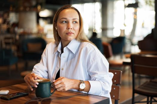 Portrait of young business woman drinking coffee in cafe
