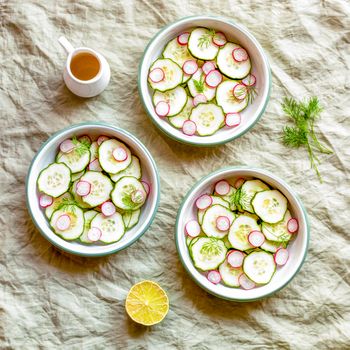 Three small round bowls with radish and cucumber summer light salad