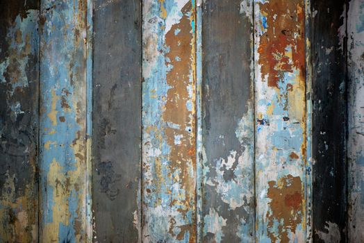 Not everything decaying is ugly. bright blue paint peeling off a rusty iron garage door.