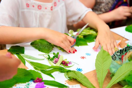 Kids making applique composition with fresh flowers