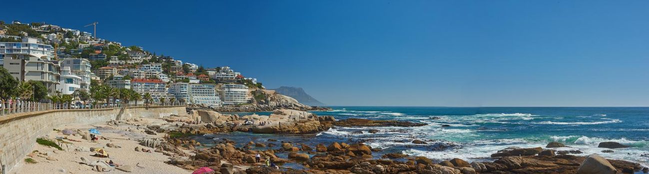 Landscape of Clifton Beach with a blue sky and copy space in Cape Town, South Africa. Luxury accommodation and holiday apartment buildings with scenic ocean views. Popular tourism summer destination