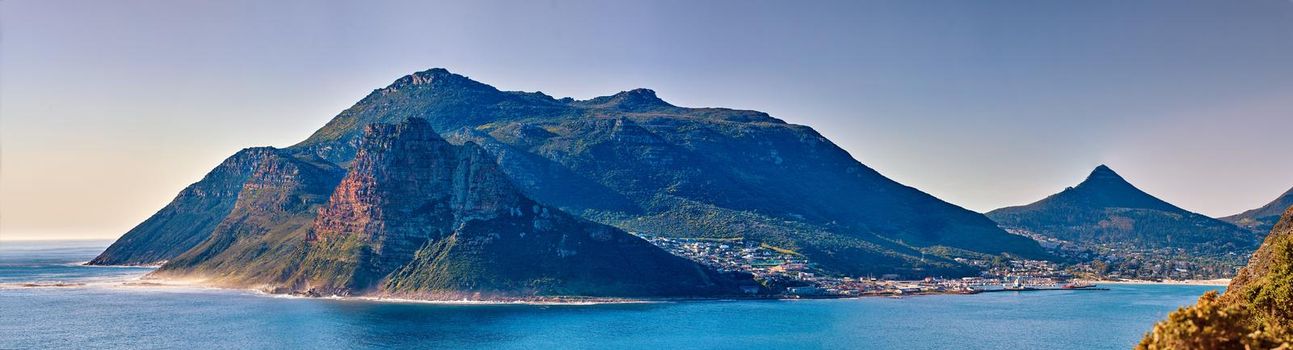 Panorama seascape, landscape, scenic view of mountains in Hout Bay in Cape Town, South Africa. Blue ocean and sea with hills. Travel and tourism abroad and overseas for a summer holiday and vacation