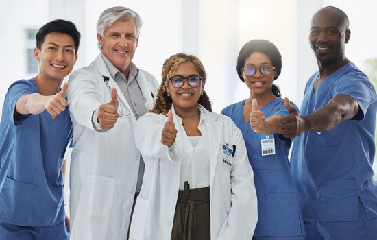 We care, collaborate and communicate to address all aspects. Portrait of a group of medical practitioners showing thumbs up together in a hospital.