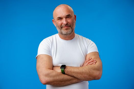 Portrait of a middle-aged man against blue background in studio