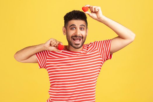 Emotional young man in red t-shirt on yellow background.