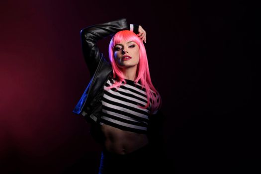 Confident young adult posing in dark pink shadow over background