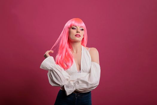 Portrait of elegant woman wearing pink hair wig in studio