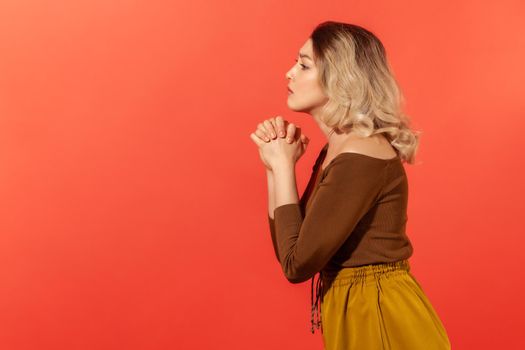 Emotional young woman on orange background.