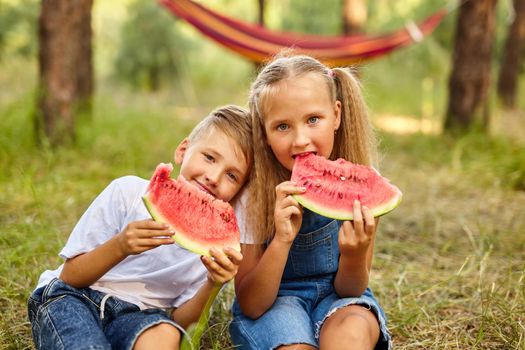 Kids eating watermelon in the park.