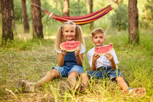 Kids eating watermelon in the park.