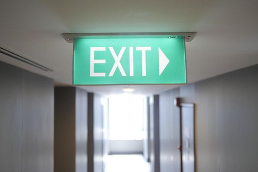 Fire exit sign in the middle of the the corridor in building