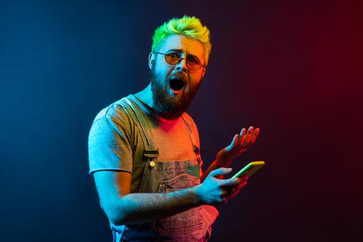 Hipster emotional man on colorful neon light background.