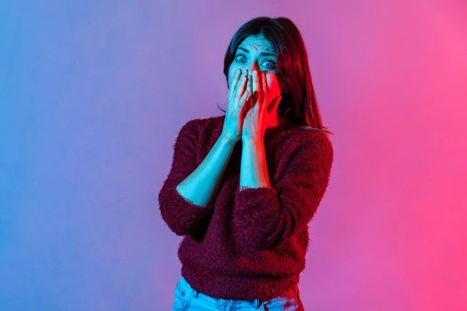 Portrait of young emotional woman on colorful neon background.