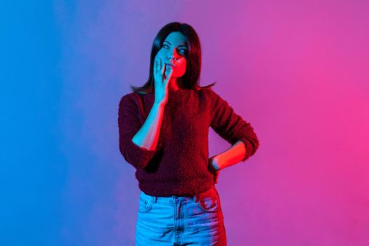 Portrait of young emotional woman on colorful neon background.
