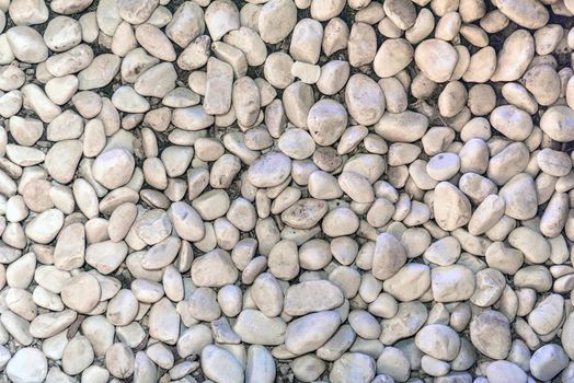 The texture of sea pebbles in cement closeup.