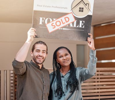 We did it. Shot of a young couple holding up a sold board outside their house.