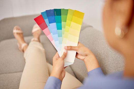 Time to decorate. Cropped shot of an unrecognisable woman standing alone at home and holding colour swatches.