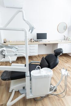 Modern dental cabinet in white colors. Defferent dental equipment, chair, lamp, drill machines. Concept dental treatment with microscope