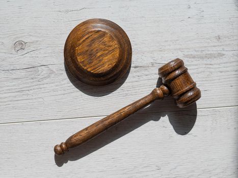Wooden judicial gavel on a wooden laminate.