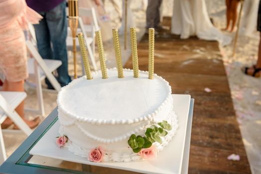 Round white wedding cake with patterns and salutes.