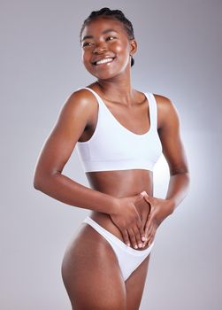 Healthy gut equals a healthy body. Shot of a young woman framing her stomach against a studio background.