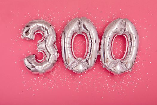 Silver balloon showing number 300 three hundred pink background