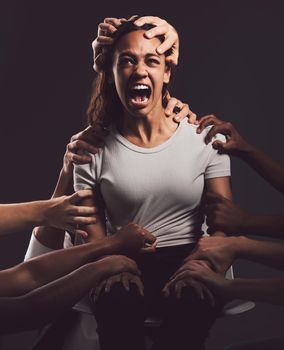 Its a wound to the soul that never heals. Shot of a young woman experiencing mental anguish and screaming against a black background.