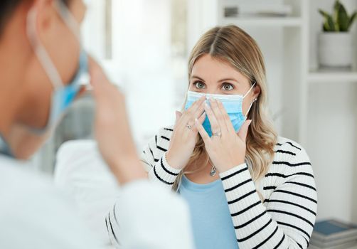 True health care is vital. Shot of two people putting on a mask in a clinic.