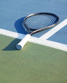 Today is to be used to be better. Shot of a tennis racket on a court during the day.