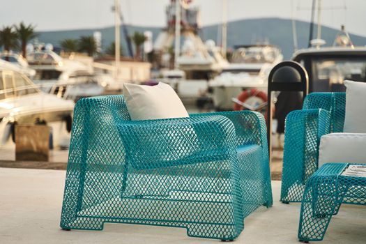 Wicker blue chairs and a table. Summer outdoor furniture on the seashore
