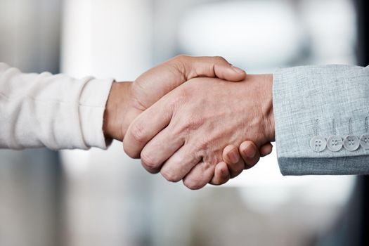 This handshake means new beginnings. Shot of two unrecognizable businespeople shaking hands in an office at work.