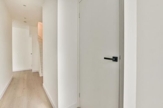 Narrow corridor with doors and lamp