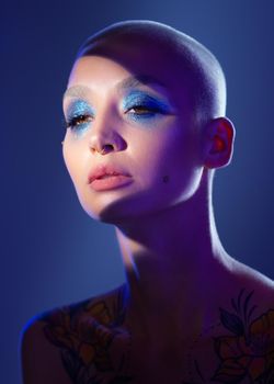 There is freedom in being bold. Studio shot of an attractive young woman wearing edgy makeup against a blue background.