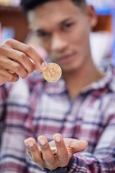 Join my peer to peer network. Shot of a young man holding bitcoins.