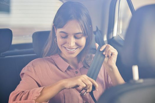 Time to hit the road. Shot of a young woman fastening her seatbelt in a car.