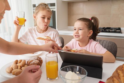 Mother and two daughters having breakfast together, happy single mother family concept