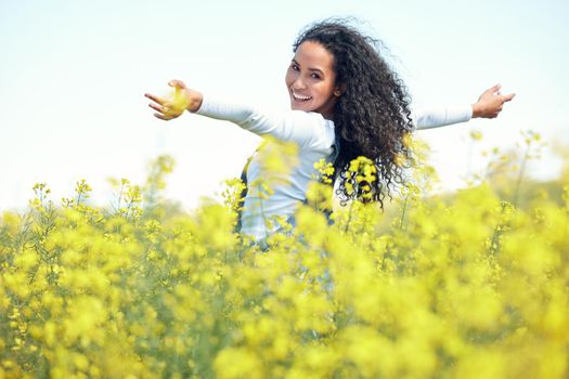 Celebrating freedom, happiness, positive thoughts and life. a beautiful young woman out in a blooming oilseed rape field.