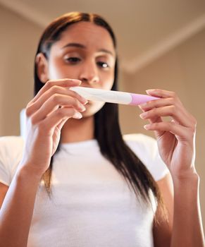 I hope its not positive. a young woman taking a pregnancy test at home.