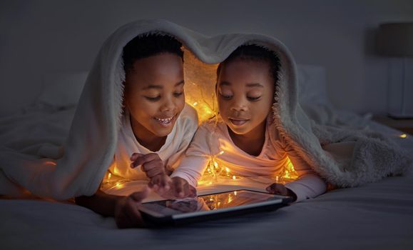 ou and I are brother and sister forever. a brother and sister using a tablet in bed at night.