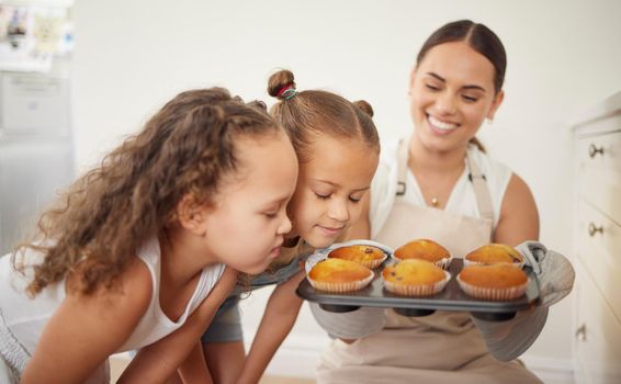 Stop and smell the goodness. a young mother and her daughter smelling the muffins they baked at home.