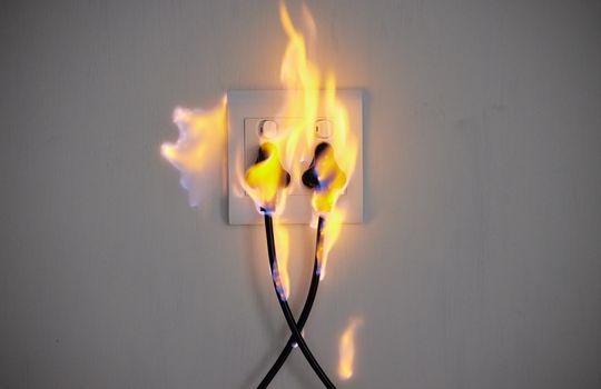 Electrical fire. two plugs in a wall socket catching fire.