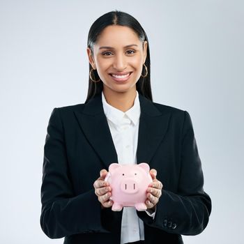 .. a young female holding a piggy bank against a grey background.