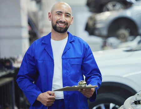Lets assess your vehicle. Cropped portrait of a handsome young male mechanic working on the engine of a car during a service.