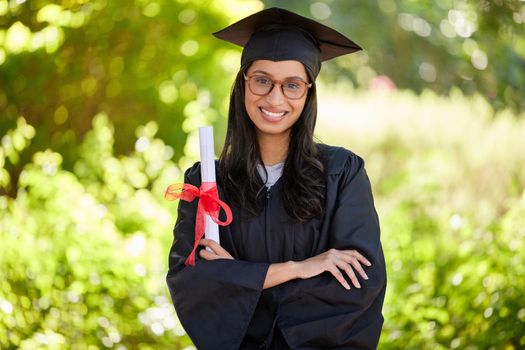 Proud of my accomplishments. Cropped portrait of an attractive young female graduate posing outside with her degree.