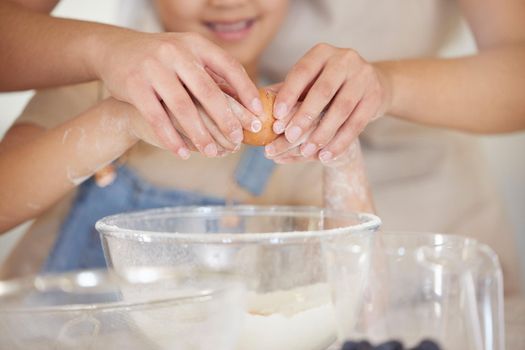 Crack it just like this. an unrecognizable parent and child baking together at home.